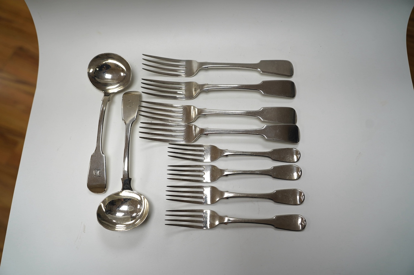 A pair of William IV silver fiddle pattern sauce ladles, William Eaton, London, 1834, 18.1cm, a set of four Victorian silver fiddle pattern table forks, Exeter, 1838 and a set of four George III silver dessert forks, Lon